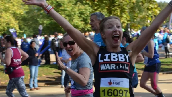 Team War Child runner Libby celebrates whilst running the Royal Parks Half