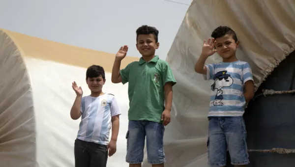 Children waving at a camp in Iraq. 