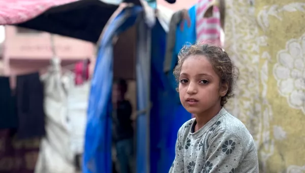 A girl sat outside in a refugee camp in Gaza. 