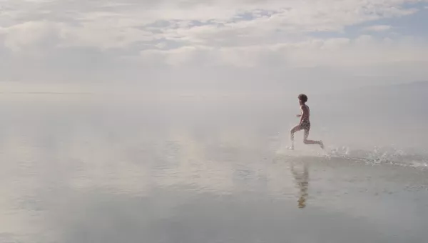 Boy running across water