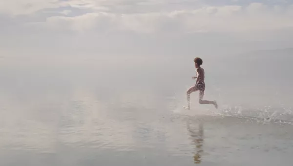 A boy running across water