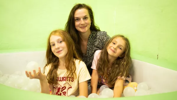 A Mother with her two daughters in a soft play area