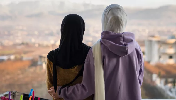 Two young girls wearing hijab looking into the distance 