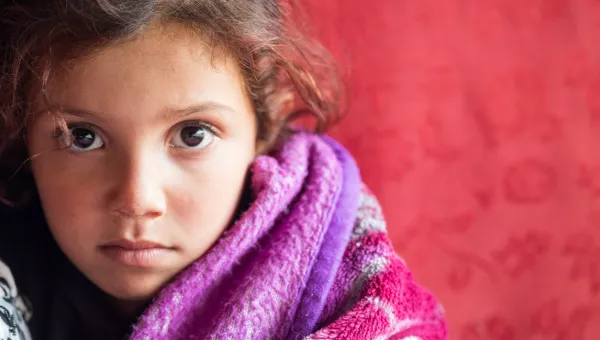 Young girl with wavy hair looking directly at the camera.