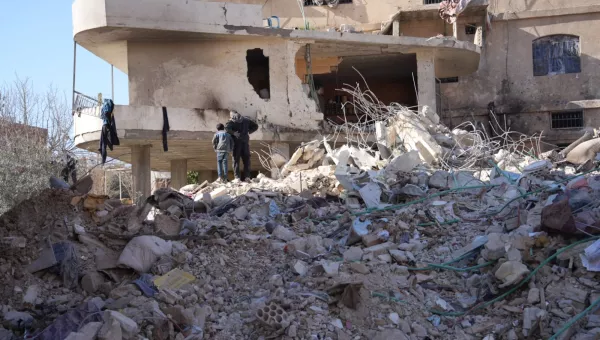 Adult and childing standing on top of building rubble