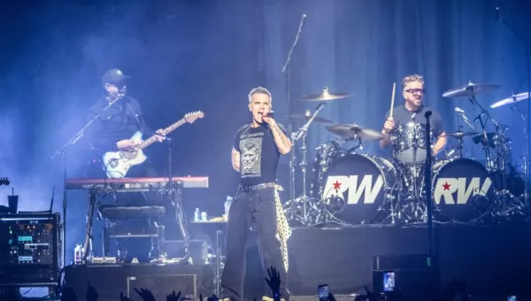 Robbie Williams standing on stage