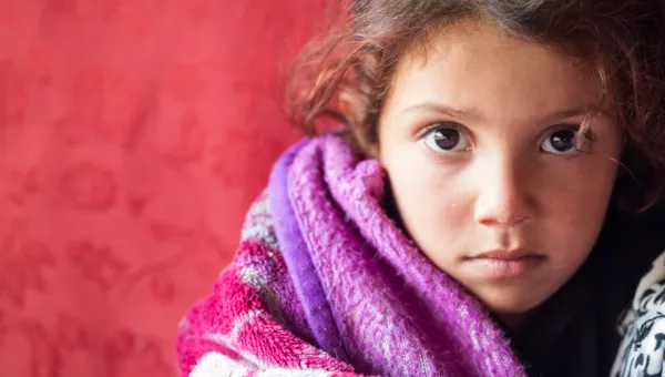 girl wrapped in blanket stares at camera