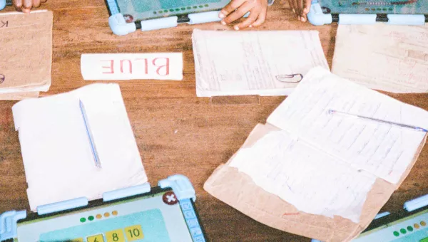 Brown school table with books and jotters.