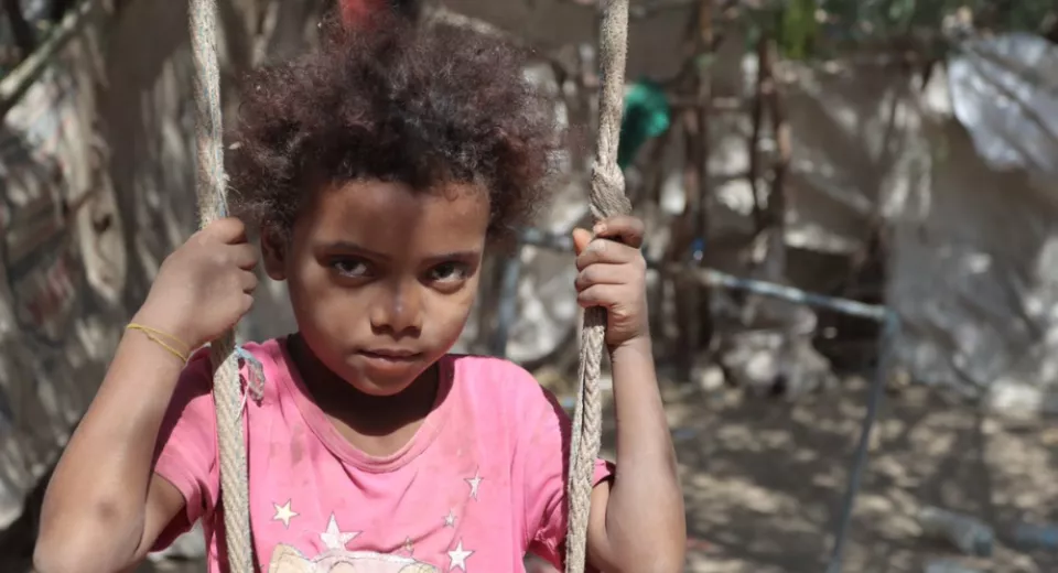 Hoda sitting on a swing in a camp in Yemen. 