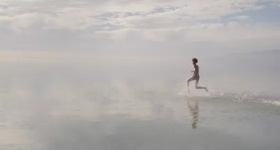 Boy running across water
