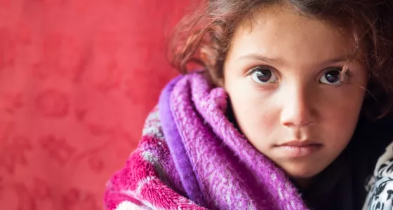 girl wrapped in blanket stares at camera