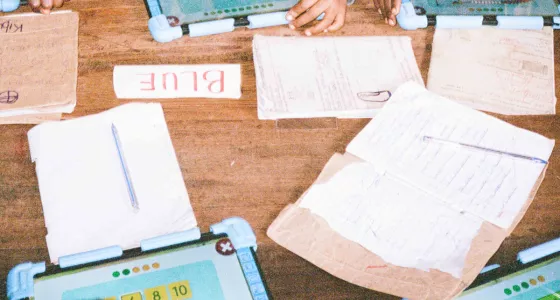 Brown school table with books and jotters.