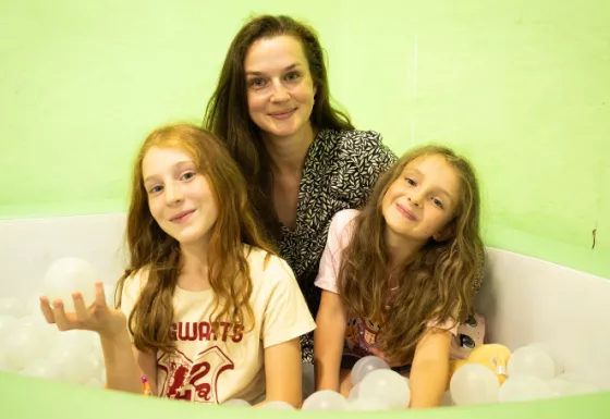 A Mother with her two daughters in a soft play area