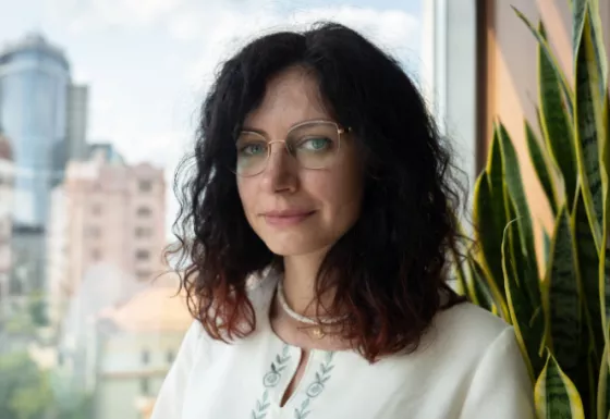 Portrait of Ukrainian women with black curly hair wearing glasses.