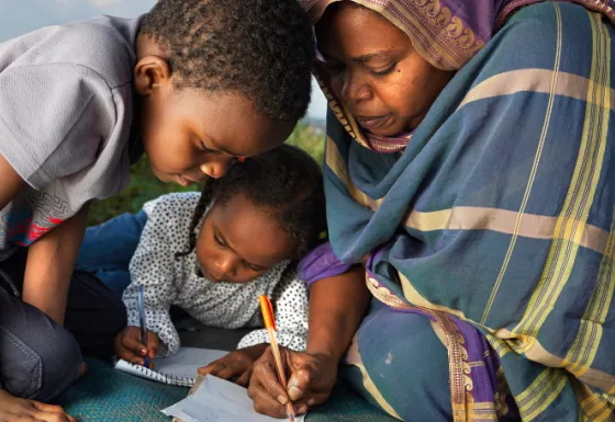 Mother helping her son and daughter with school work.