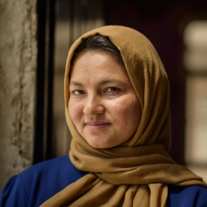 Afghan lady wearing a brown hijab and smiling
