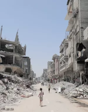 Child running in Gaza in between collapsed buildings. 